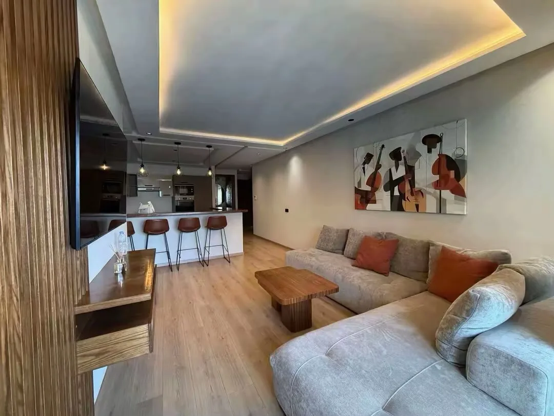 Bright living room, with a corner sofa and illuminated ceiling
