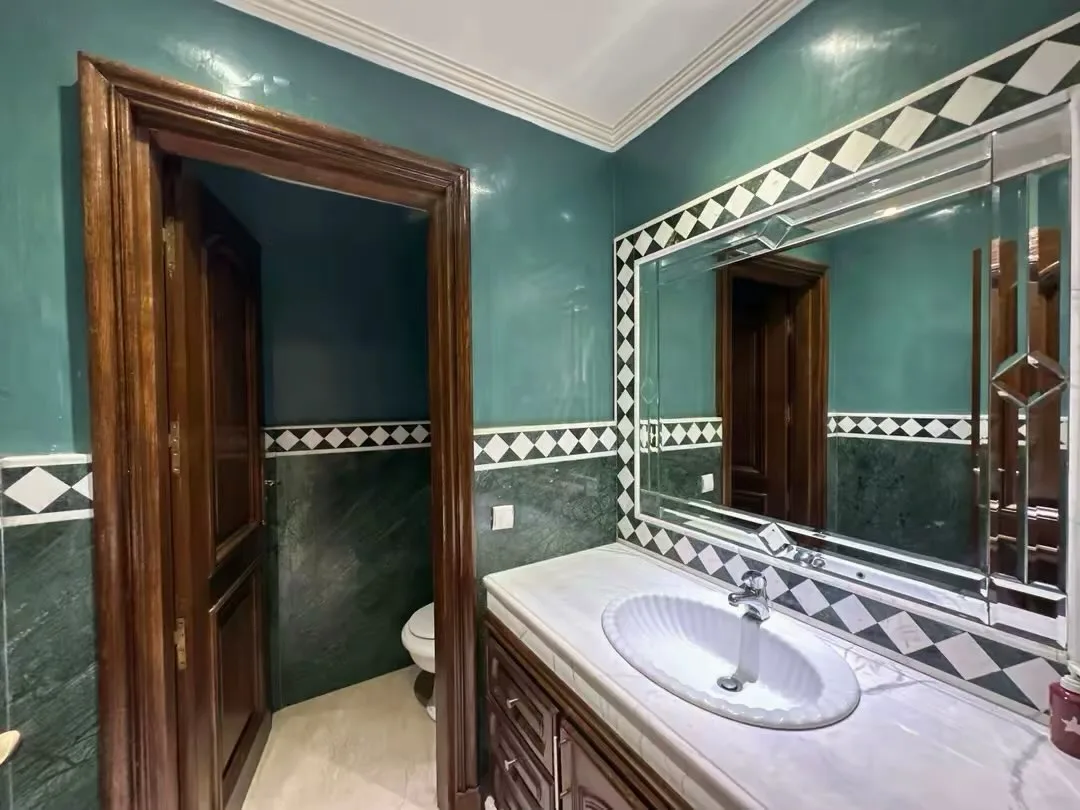 Bathroom with green walls and zellige frieze